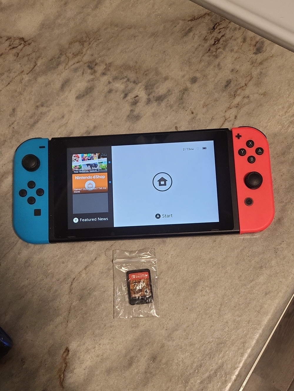 Nintendo Switch Console with Red Joy-Con and Zelda Game Card